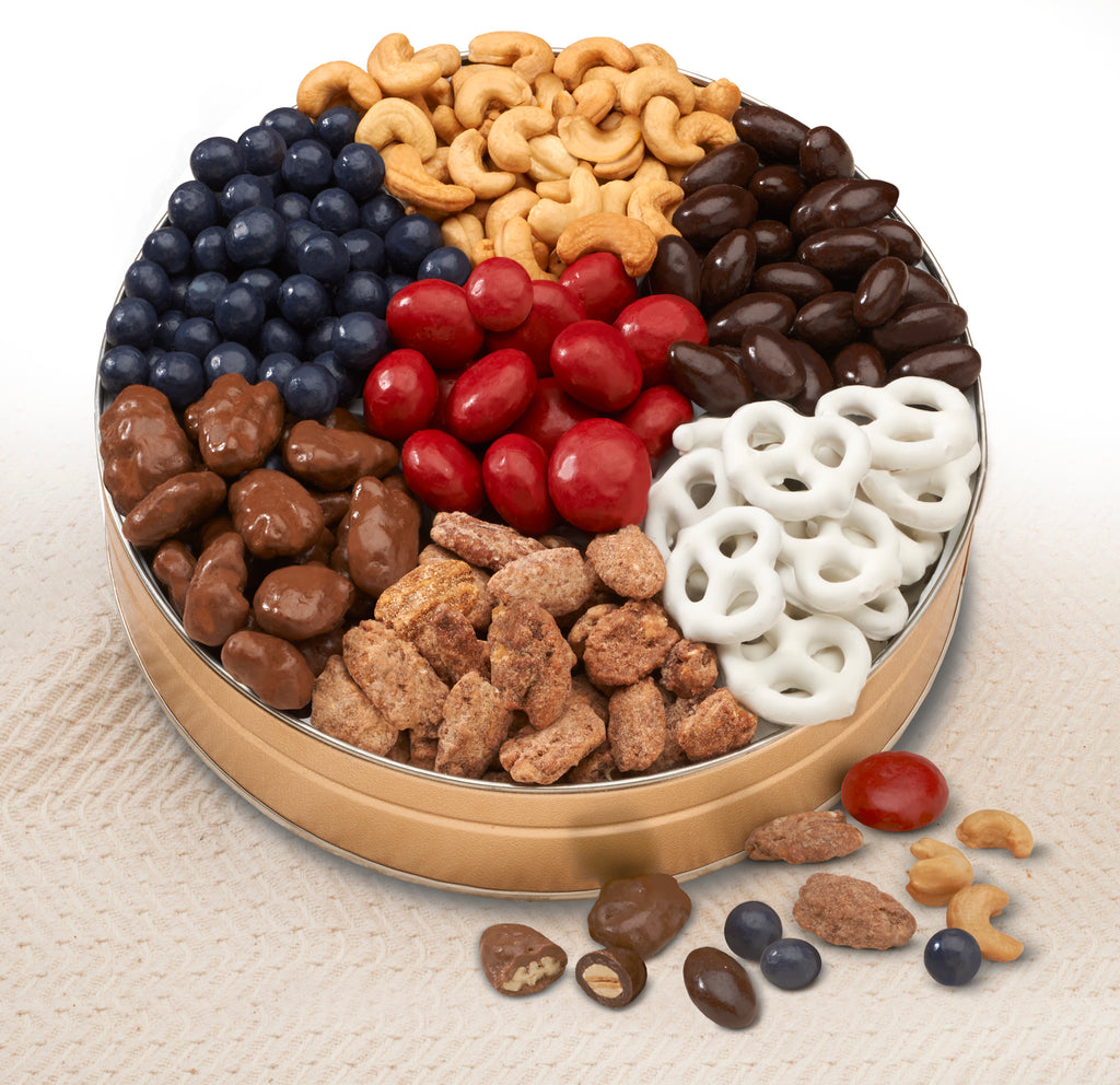 Nut Tin Gift: Bing Cherries, Blueberries, and mouth-watering White Chocolate Pretzels,  They'll also get jumbo Whole Cashews, Chocolate Almonds, Chocolate-covered Pecans, and premium Praline Pecans. 	