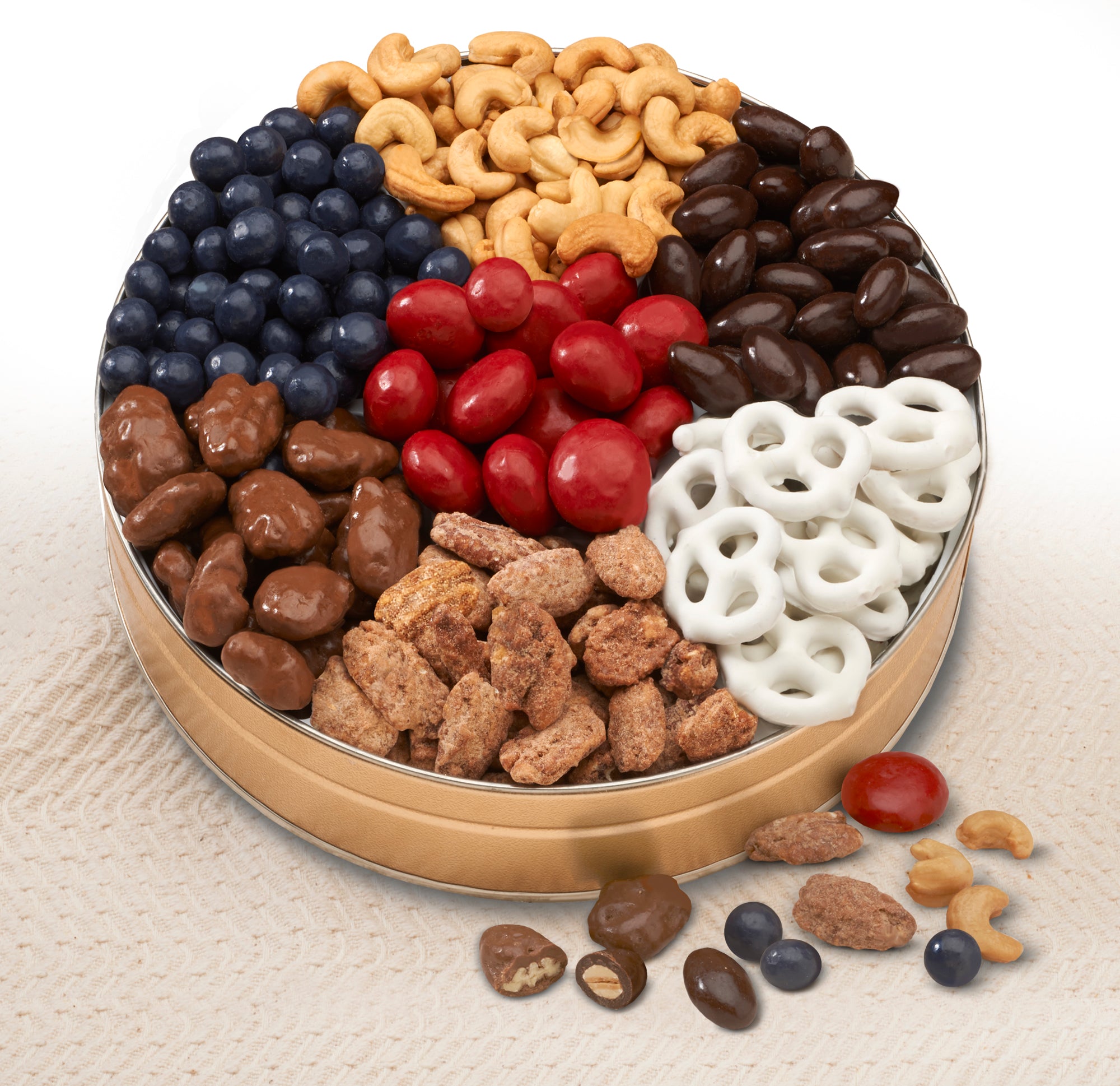 Nut Tin Gift: Bing Cherries, Blueberries, and mouth-watering White Chocolate Pretzels,  They'll also get jumbo Whole Cashews, Chocolate Almonds, Chocolate-covered Pecans, and premium Praline Pecans. 	
